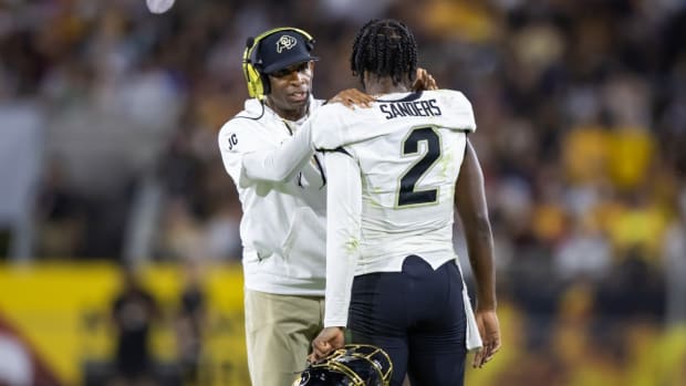 Deion Sanders speaks to his son, Colorado quarterback Shedeur Sanders during a game.